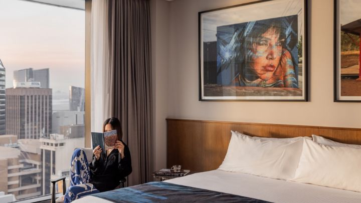 A woman reading a magazine inside an art-filled hotel room